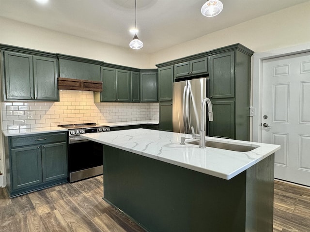 kitchen with sink, light stone counters, decorative light fixtures, an island with sink, and stainless steel appliances