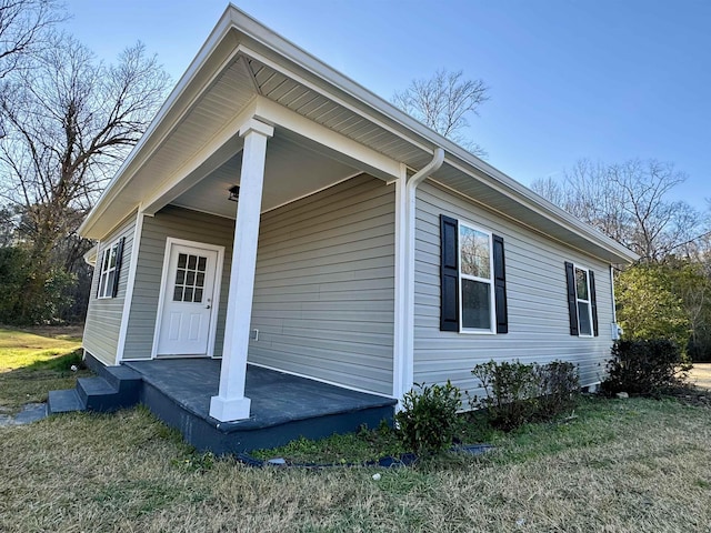 exterior space featuring covered porch and a lawn