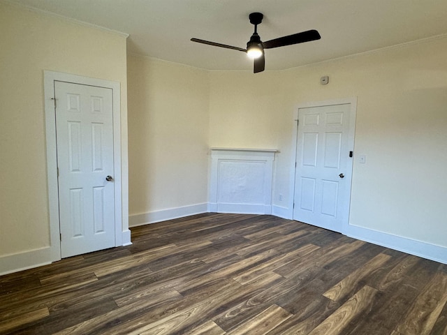 spare room with dark hardwood / wood-style flooring, ornamental molding, and ceiling fan