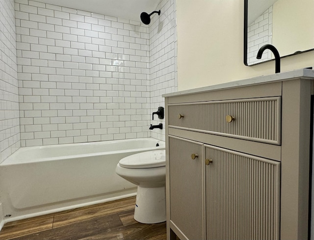 bathroom featuring toilet, tiled shower / bath combo, and hardwood / wood-style floors