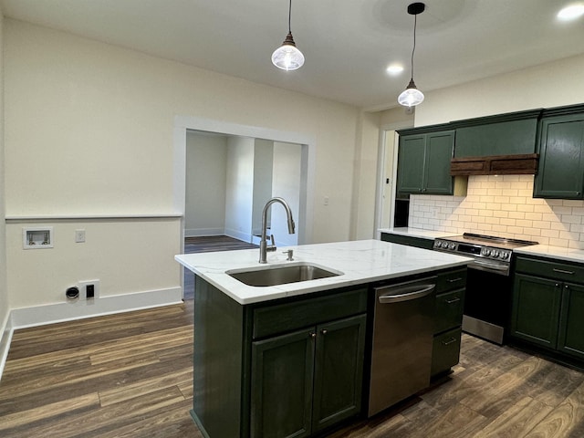 kitchen featuring appliances with stainless steel finishes, dark hardwood / wood-style floors, sink, hanging light fixtures, and a kitchen island with sink