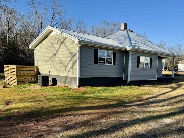 view of side of home with a yard and central AC unit