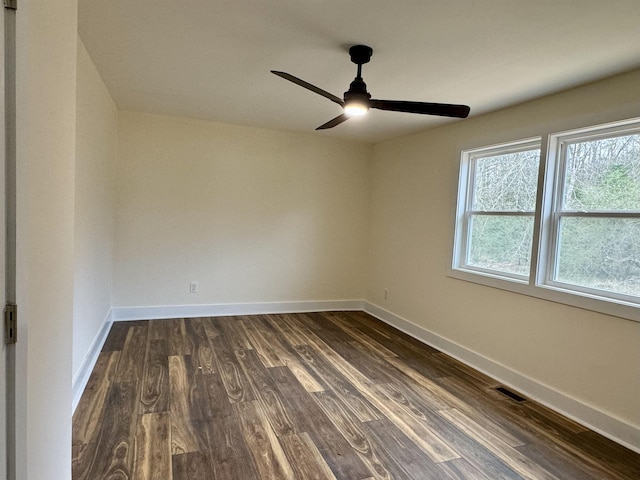 empty room with ceiling fan and dark hardwood / wood-style flooring