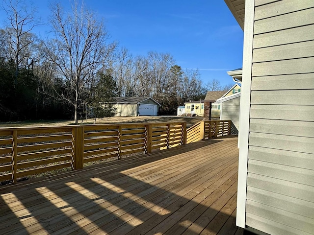 wooden deck featuring a garage and an outdoor structure