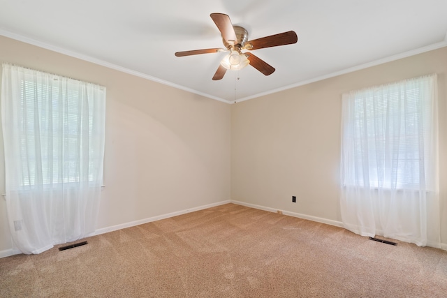 empty room featuring crown molding, light colored carpet, and ceiling fan