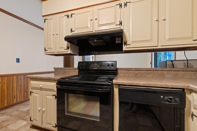 kitchen featuring cream cabinets, ventilation hood, black appliances, and wooden walls