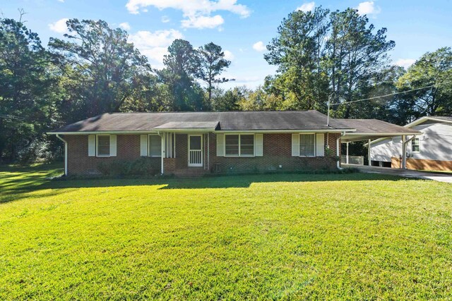 ranch-style home featuring a carport and a front lawn