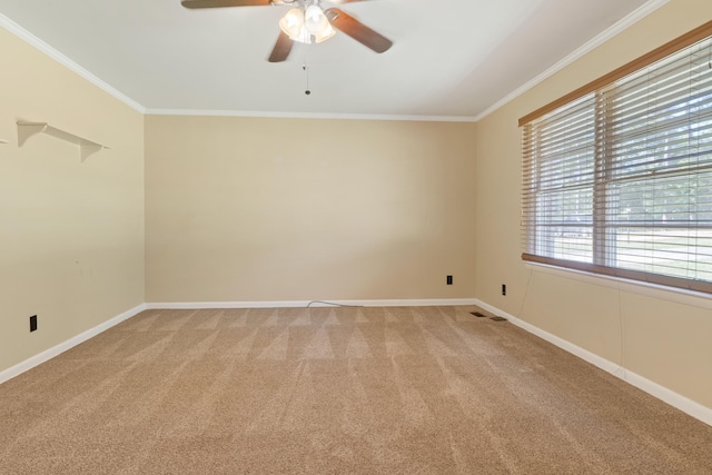 empty room with crown molding, ceiling fan, and carpet