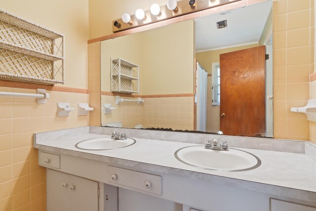 bathroom featuring crown molding, vanity, and tile walls