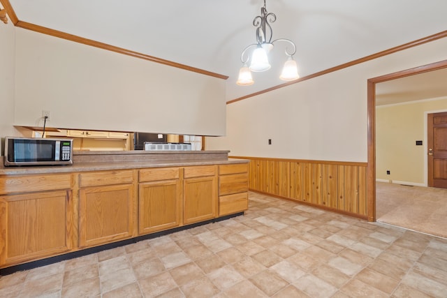 kitchen with hanging light fixtures, crown molding, and wooden walls