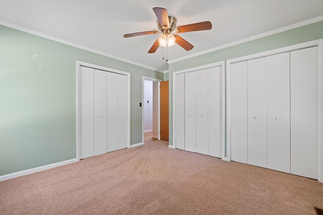 unfurnished bedroom featuring light carpet, two closets, ornamental molding, and ceiling fan