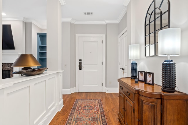 foyer entrance with wood-type flooring and crown molding