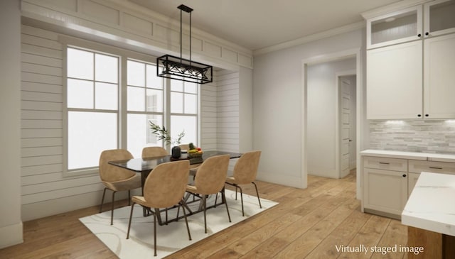 dining room featuring crown molding and light hardwood / wood-style flooring