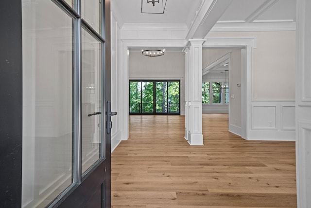 hallway featuring ornate columns, crown molding, and light hardwood / wood-style flooring