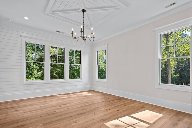 unfurnished room with a notable chandelier and light hardwood / wood-style floors