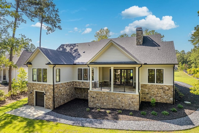 rear view of property featuring a porch and a garage