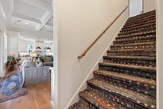 stairs featuring beamed ceiling, wood finished floors, recessed lighting, and coffered ceiling