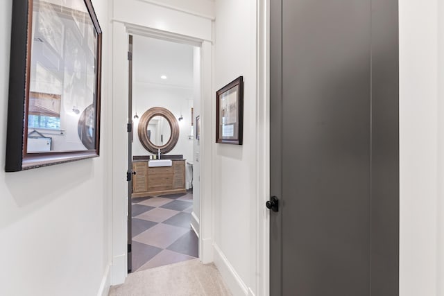 hallway featuring baseboards and carpet flooring