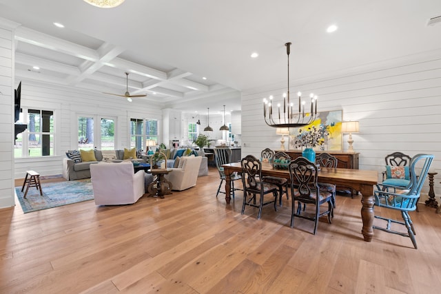 dining room with beamed ceiling, a wealth of natural light, light wood-style floors, and coffered ceiling