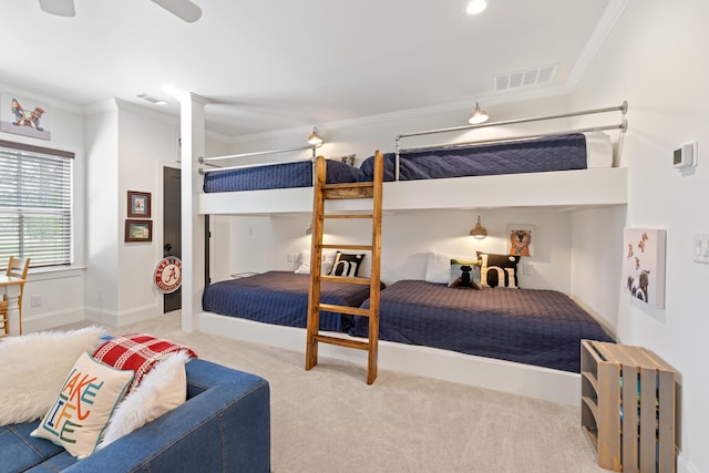 carpeted bedroom featuring ceiling fan, baseboards, crown molding, and visible vents