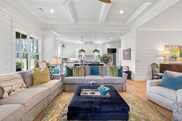 living area featuring recessed lighting, wooden walls, visible vents, beam ceiling, and light wood-style flooring