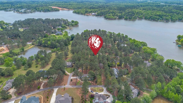 birds eye view of property featuring a forest view and a water view