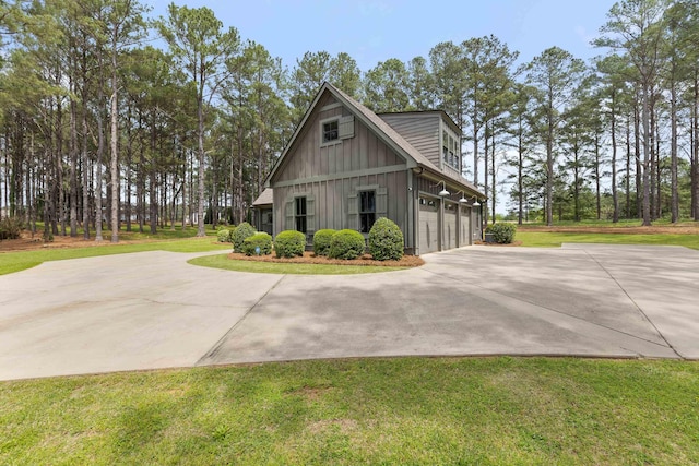 view of home's exterior with board and batten siding, an attached garage, a lawn, and concrete driveway