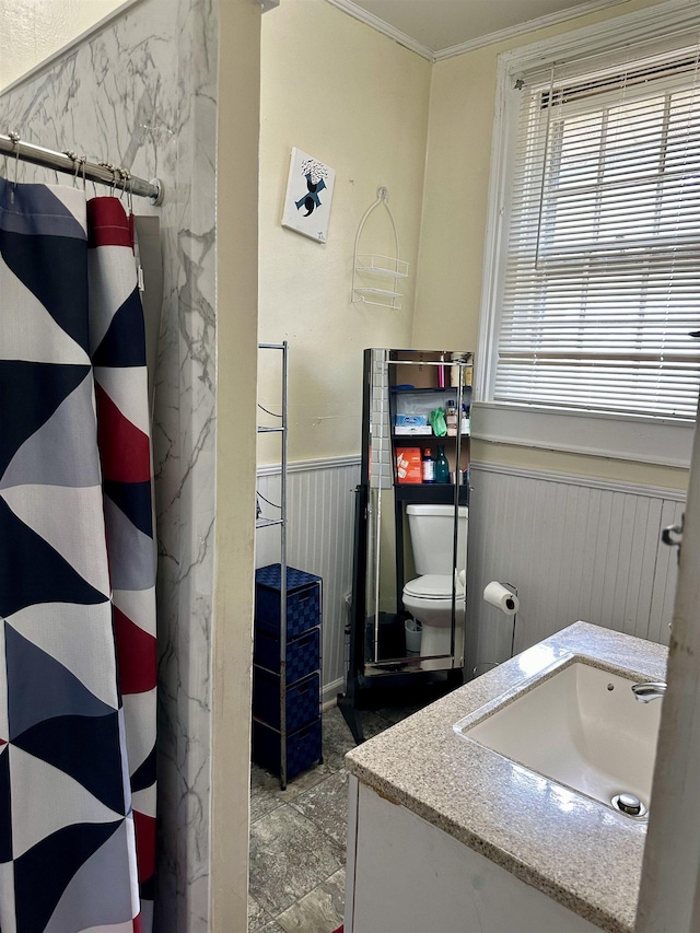 bathroom featuring vanity, crown molding, toilet, and wood walls