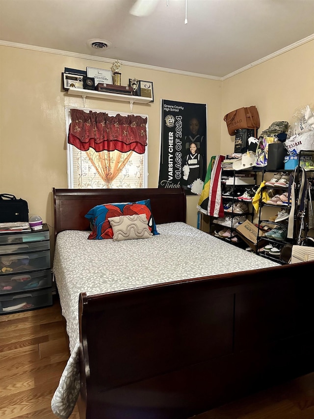 bedroom featuring hardwood / wood-style flooring, ceiling fan, and ornamental molding