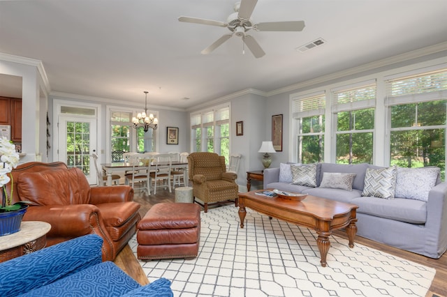 living room with ornamental molding, ceiling fan with notable chandelier, and light wood-type flooring