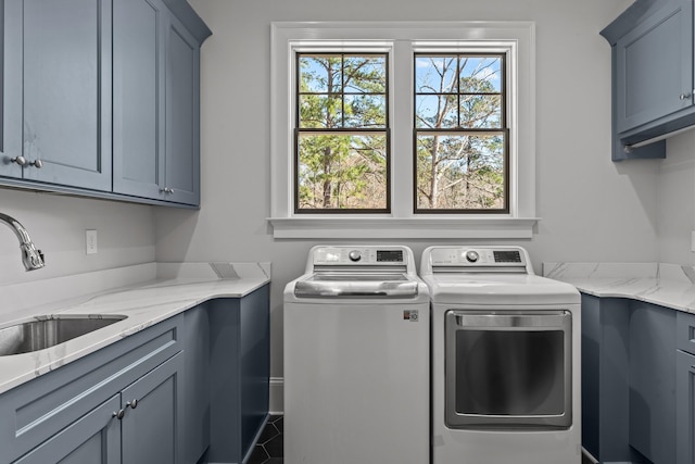 clothes washing area featuring tile patterned flooring, cabinet space, independent washer and dryer, and a sink