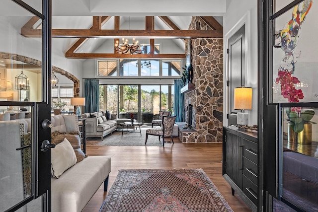 interior space with a notable chandelier, a healthy amount of sunlight, wood finished floors, and a fireplace