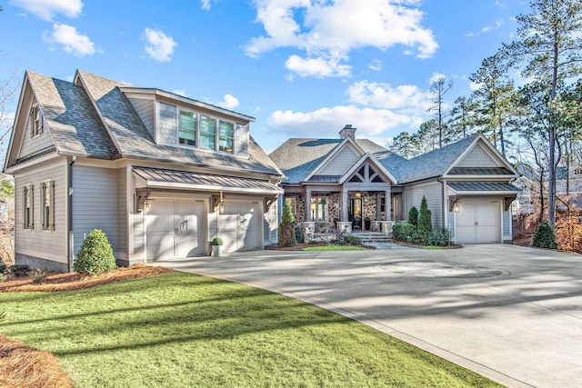 view of front facade with driveway, a standing seam roof, a front yard, a shingled roof, and a garage