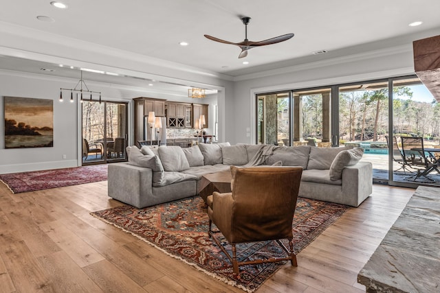 living room with a wealth of natural light, visible vents, and crown molding