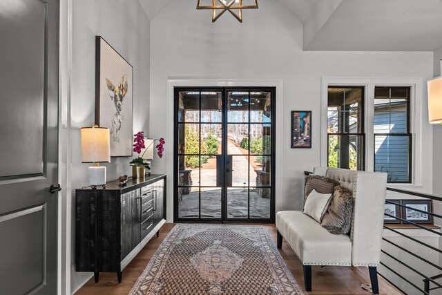 doorway with french doors, lofted ceiling, and dark wood finished floors