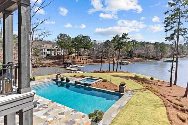 pool featuring a water view, a lawn, an in ground hot tub, and a patio area