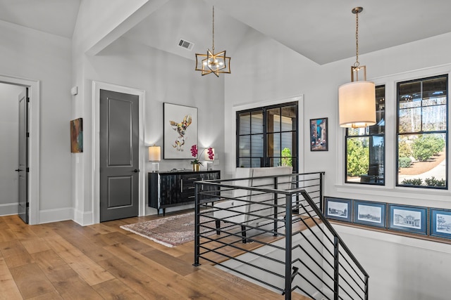 dining space featuring a wealth of natural light, visible vents, an inviting chandelier, and hardwood / wood-style floors