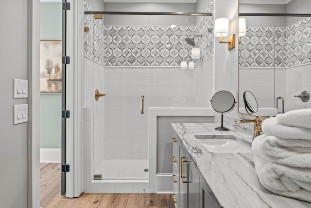 bathroom with vanity, wood finished floors, and a shower stall