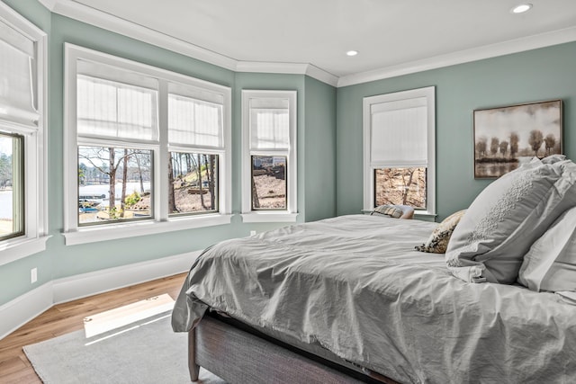 bedroom with crown molding, recessed lighting, wood finished floors, and baseboards