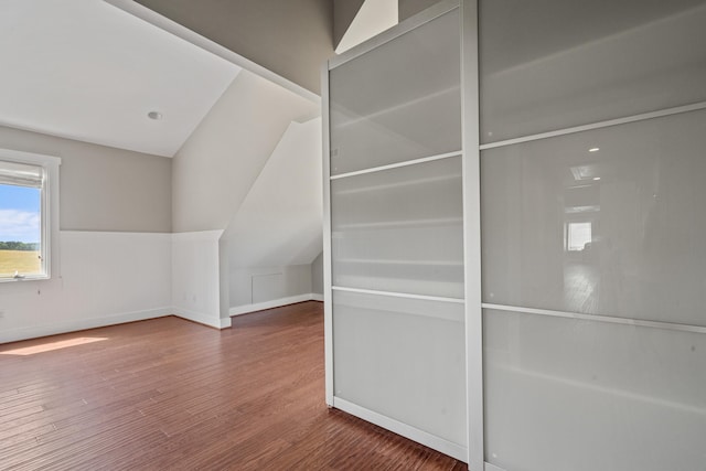 bonus room with wood-type flooring and vaulted ceiling