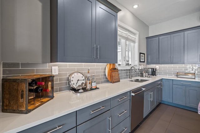 kitchen with dishwasher, sink, dark tile patterned flooring, and backsplash