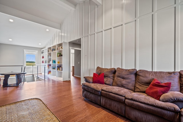 living room with vaulted ceiling, hardwood / wood-style floors, and built in shelves