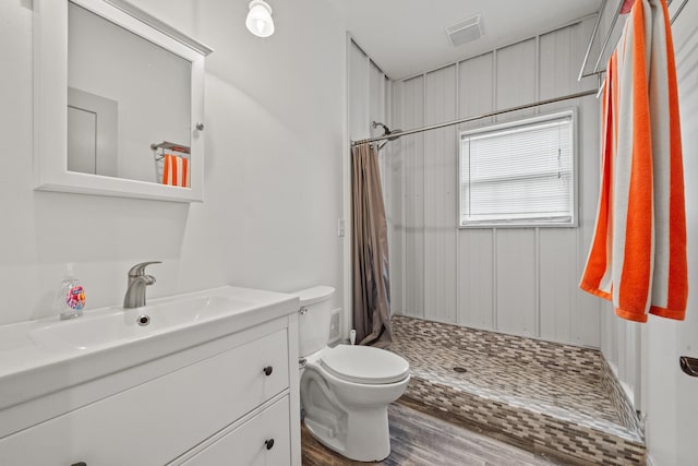 bathroom featuring vanity, wood-type flooring, curtained shower, and toilet