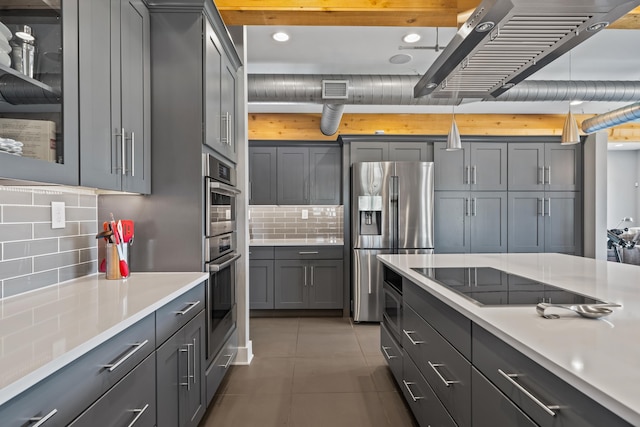 kitchen featuring appliances with stainless steel finishes, gray cabinetry, light tile patterned floors, and decorative backsplash