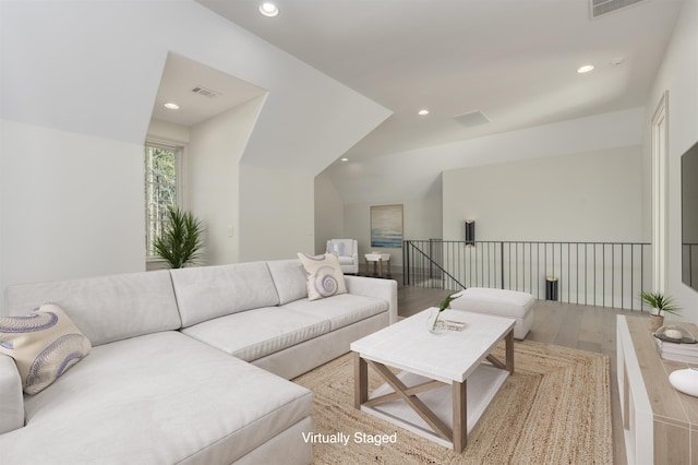 living room with vaulted ceiling and hardwood / wood-style floors