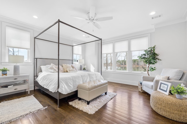 bedroom featuring dark wood-type flooring, visible vents, crown molding, and baseboards