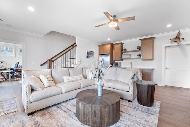 living area featuring stairway, ornamental molding, and recessed lighting