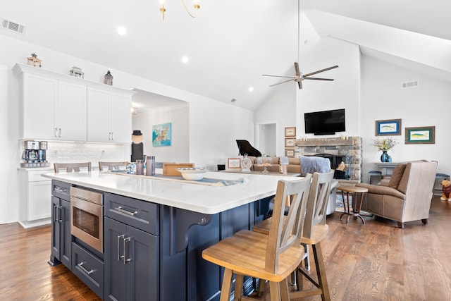 kitchen featuring open floor plan, light countertops, visible vents, and white cabinetry