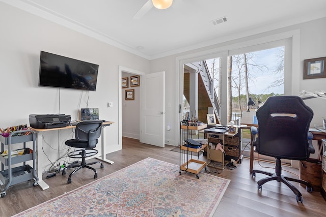 office featuring baseboards, visible vents, a ceiling fan, wood finished floors, and crown molding