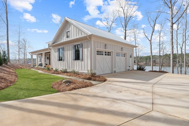 garage with a water view, a porch, and concrete driveway